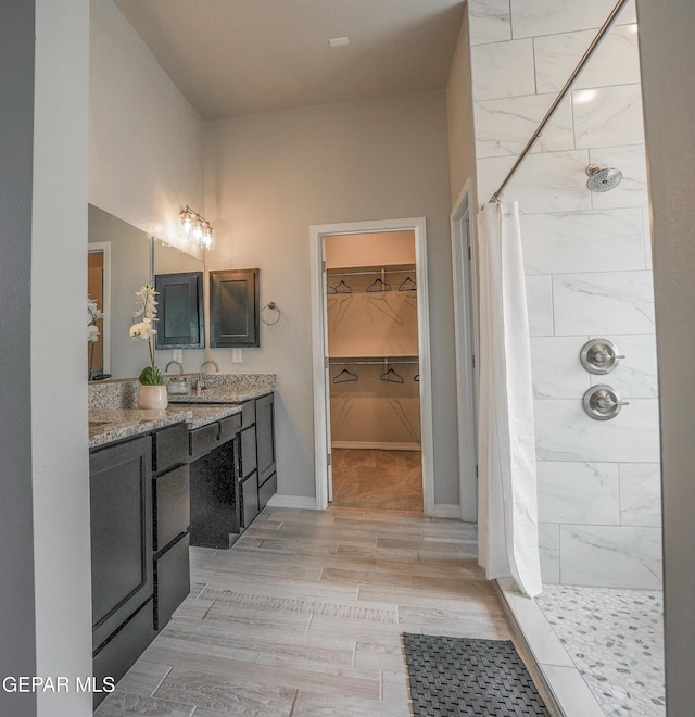 3853 Surmise St, El Paso, TX 79938 - bathroom with a tile shower, double vanity, and a spacious closet