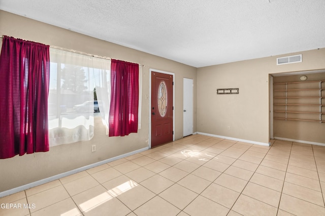 foyer featuring visible vents, a textured ceiling, and light tile patterned floors