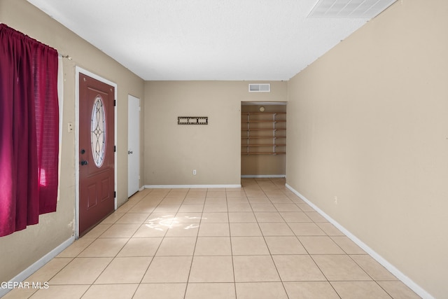 entrance foyer featuring light tile patterned flooring, visible vents, and baseboards