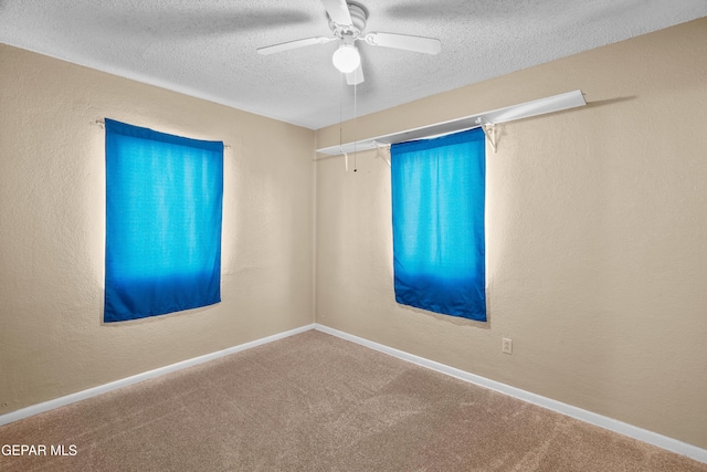 empty room featuring carpet flooring, a textured wall, a textured ceiling, and baseboards