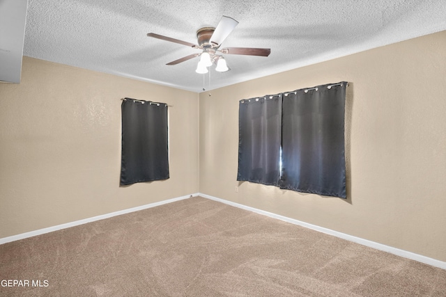 carpeted empty room featuring ceiling fan, a textured wall, a textured ceiling, and baseboards