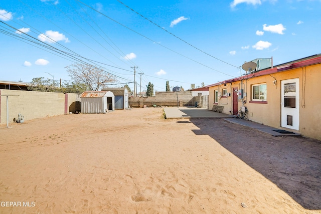 view of yard with a storage unit, an outdoor structure, and a fenced backyard