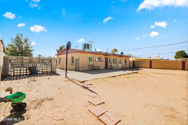 rear view of house with a patio, central AC unit, and a fenced backyard