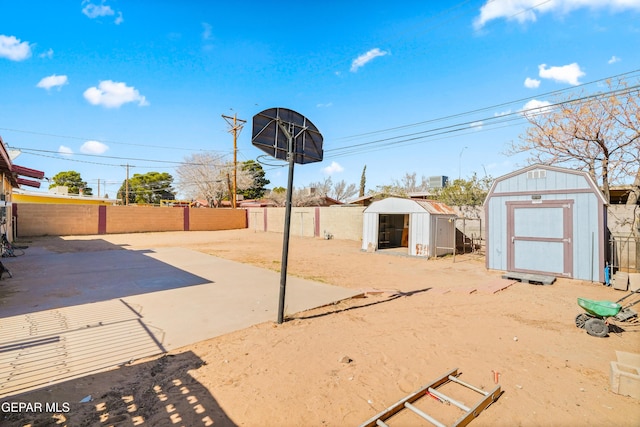 view of yard with an outbuilding, a patio area, a fenced backyard, and a storage shed