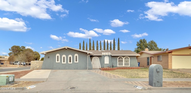 single story home with concrete driveway and stucco siding