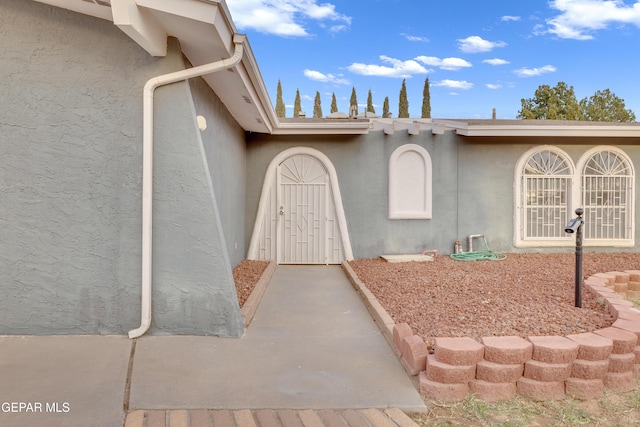 view of exterior entry featuring stucco siding