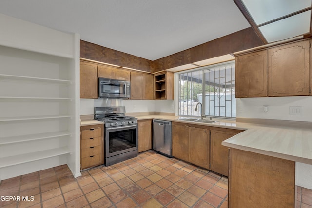 kitchen with light countertops, appliances with stainless steel finishes, open shelves, and a sink