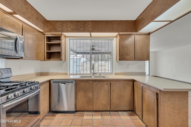 kitchen with open shelves, light countertops, appliances with stainless steel finishes, a sink, and a peninsula