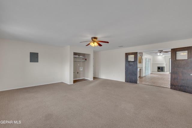 unfurnished room with light carpet, a ceiling fan, and electric panel