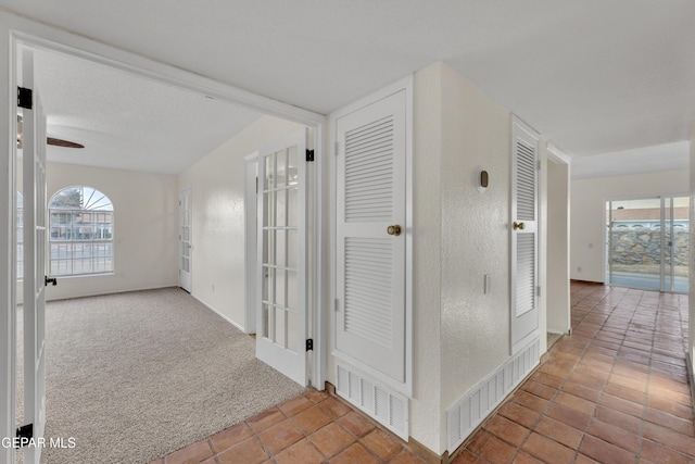 hall with carpet and visible vents