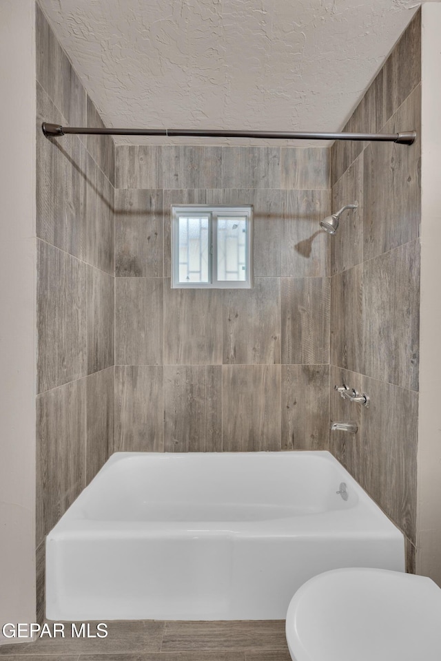 bathroom with a textured ceiling and toilet