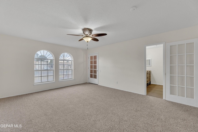 unfurnished room featuring a textured ceiling, ceiling fan, and carpet flooring