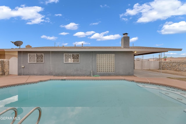 pool with a patio and fence