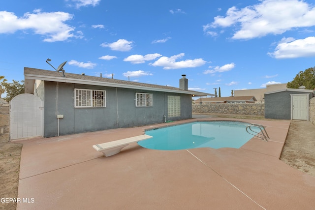 view of pool featuring a patio area, fence, a diving board, and a fenced in pool