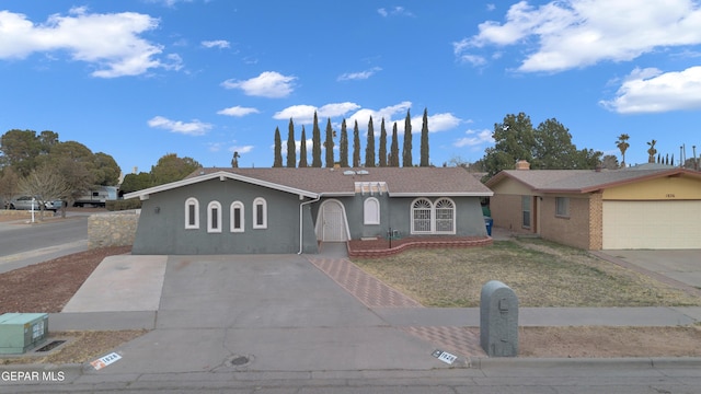 ranch-style house featuring concrete driveway and stucco siding