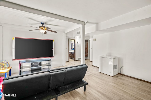 living room with baseboards, a ceiling fan, visible vents, and light wood-style floors