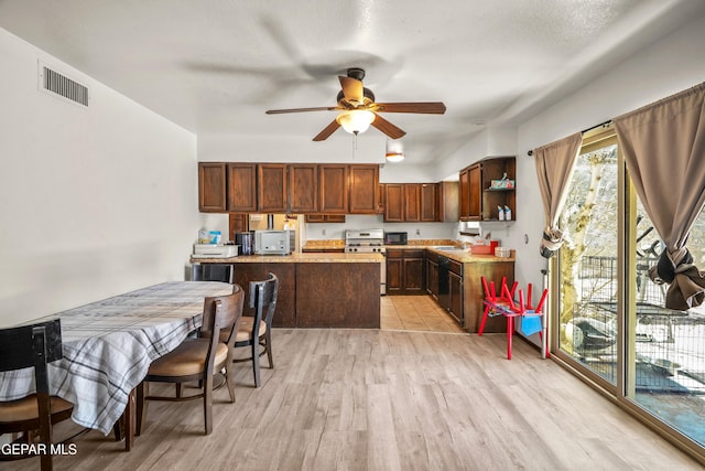 kitchen with visible vents, light wood-style flooring, light countertops, stainless steel range oven, and a sink