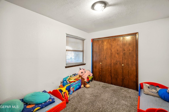 playroom with a textured ceiling and carpet flooring