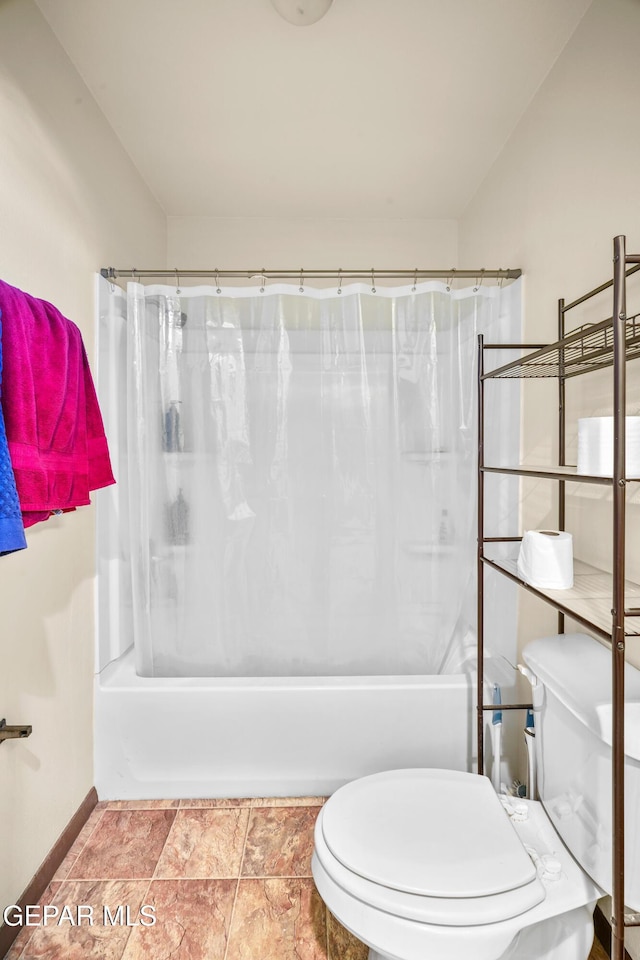 bathroom featuring shower / bath combination with curtain, baseboards, and toilet