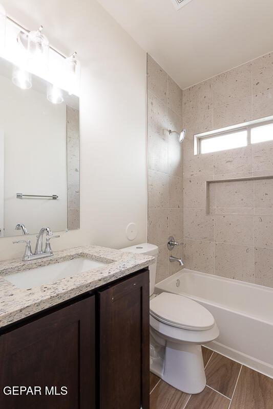 bathroom featuring shower / bathing tub combination, vanity, toilet, and wood finished floors