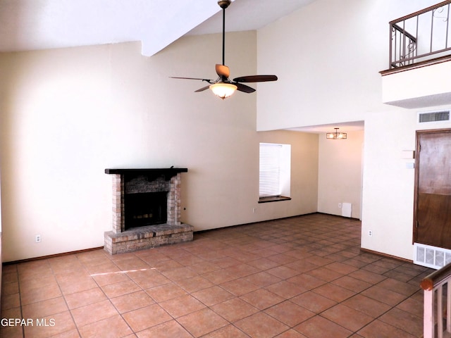 unfurnished living room with a ceiling fan, visible vents, a fireplace, and tile patterned floors