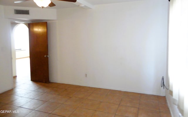 spare room with ceiling fan, light tile patterned flooring, visible vents, and baseboards