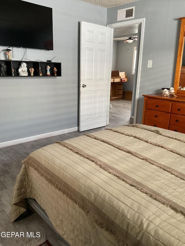 bedroom with baseboards, visible vents, and dark wood-style flooring