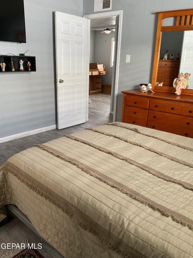 bedroom featuring visible vents, baseboards, and dark wood finished floors