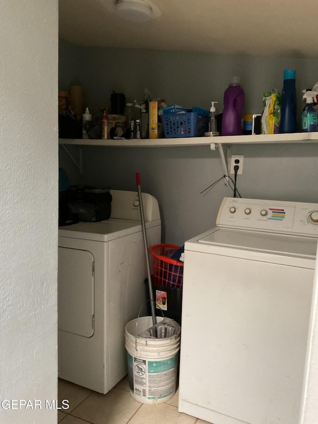 clothes washing area with laundry area, tile patterned flooring, and independent washer and dryer