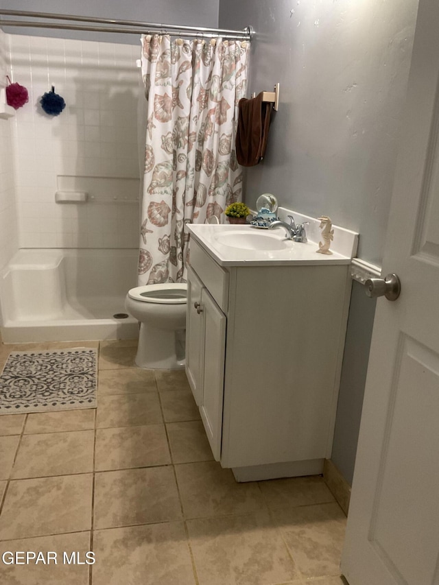 full bathroom featuring tile patterned flooring, a shower stall, toilet, and vanity