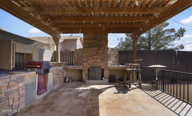 view of patio / terrace with area for grilling, an outdoor kitchen, fence, and a pergola