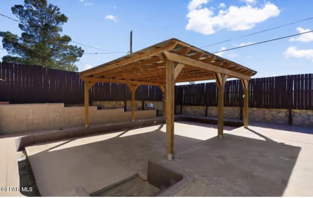 view of patio / terrace with a detached carport and fence