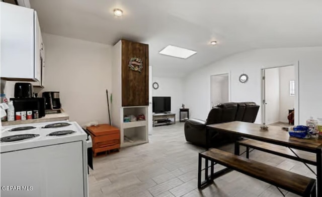 kitchen with white cabinets, vaulted ceiling, light countertops, open floor plan, and white range with electric stovetop