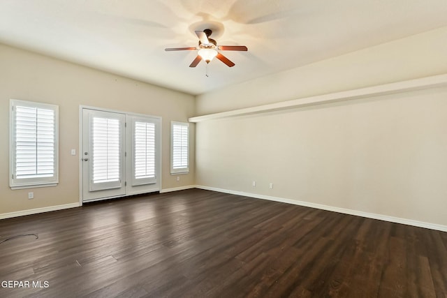 empty room with dark wood-type flooring, ceiling fan, and baseboards