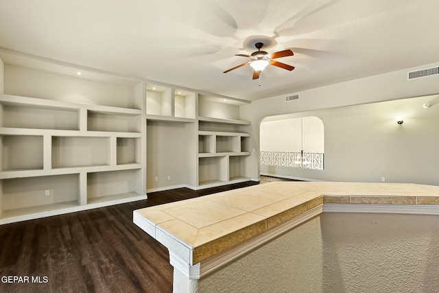 interior space featuring ceiling fan, dark wood-style flooring, and visible vents