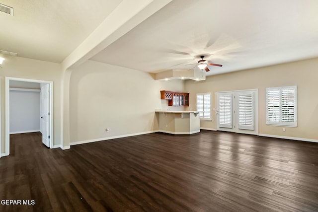 unfurnished living room featuring visible vents, dark wood finished floors, baseboards, and ceiling fan