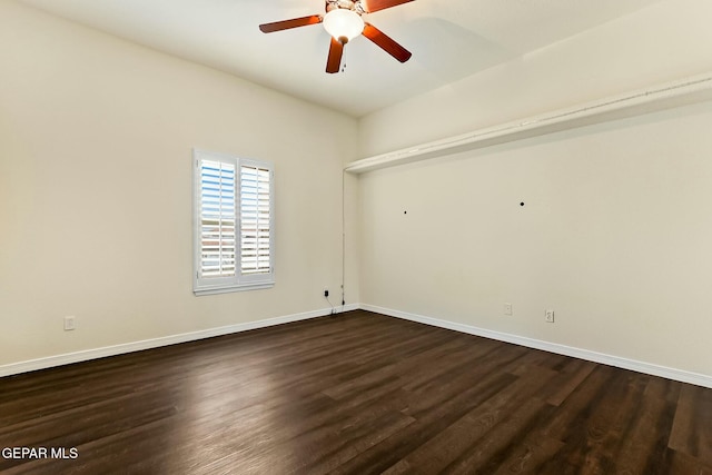 spare room featuring dark wood-style floors, baseboards, and a ceiling fan