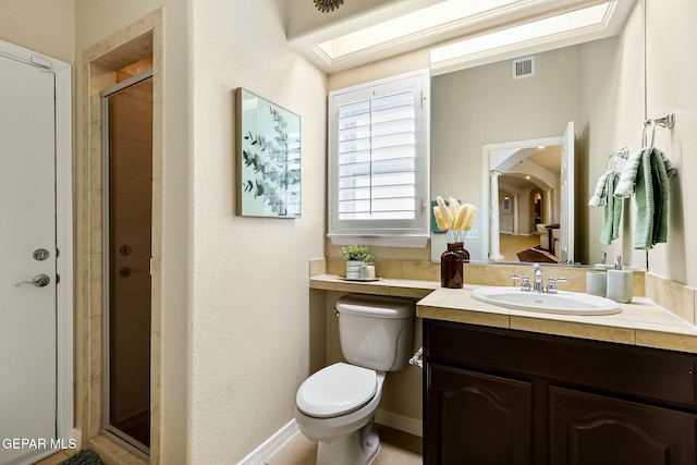 bathroom with toilet, a shower stall, visible vents, and vanity