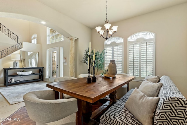 dining space featuring stairway, arched walkways, a wealth of natural light, and ornate columns