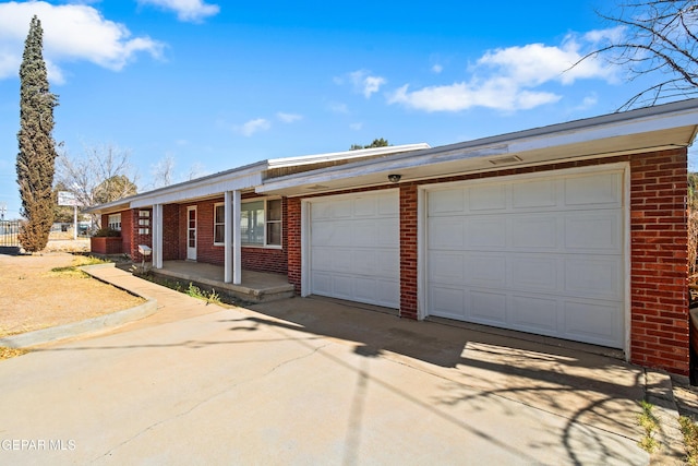 ranch-style house with covered porch, brick siding, driveway, and an attached garage