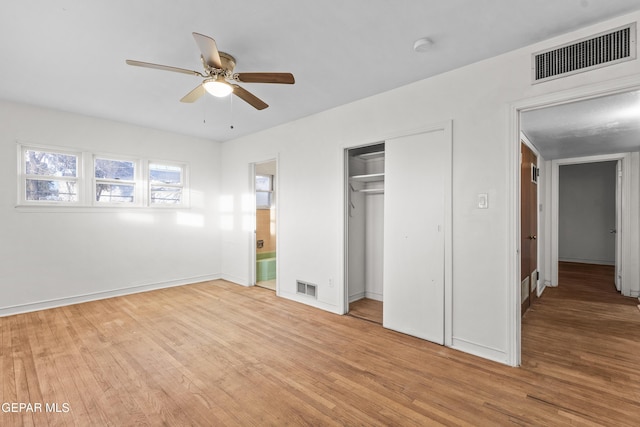 unfurnished bedroom featuring light wood-style floors, visible vents, and a closet