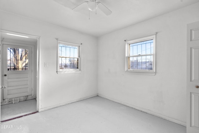 empty room with concrete flooring and a ceiling fan