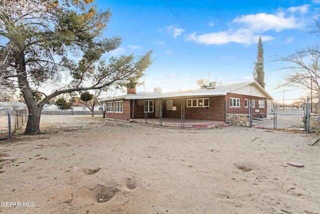 rear view of property with a patio, brick siding, and fence