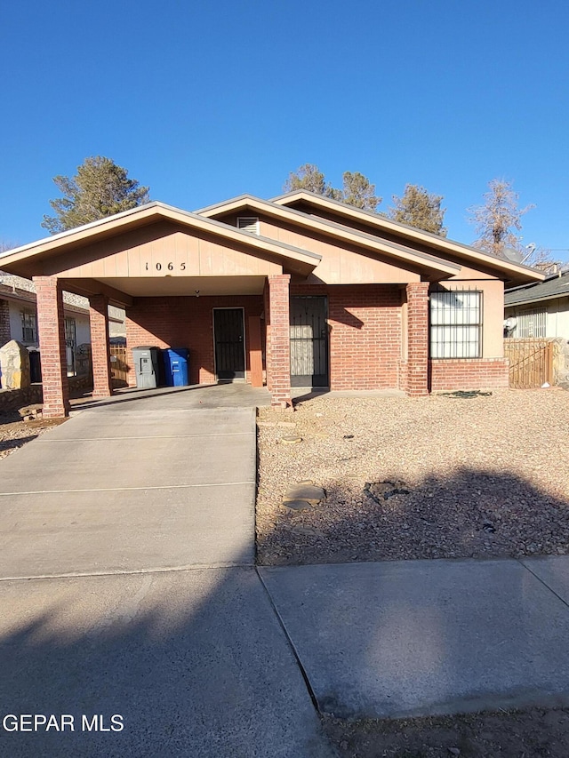 view of front of house featuring driveway and brick siding