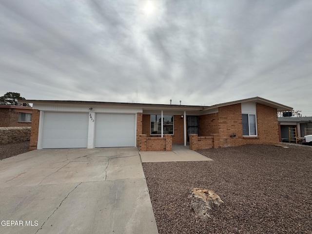 ranch-style house featuring an attached garage, brick siding, and driveway