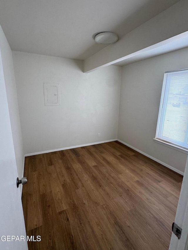 empty room featuring baseboards and wood finished floors