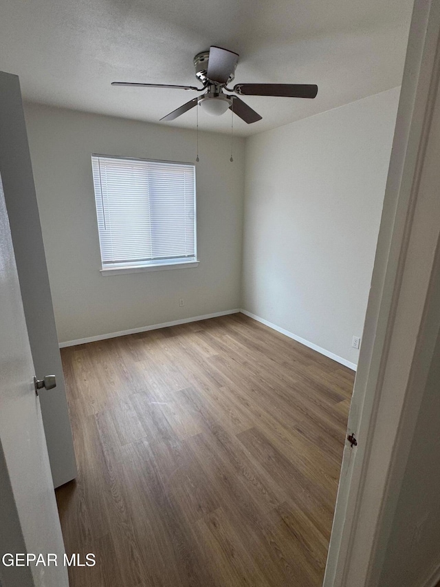 unfurnished room featuring baseboards and wood finished floors