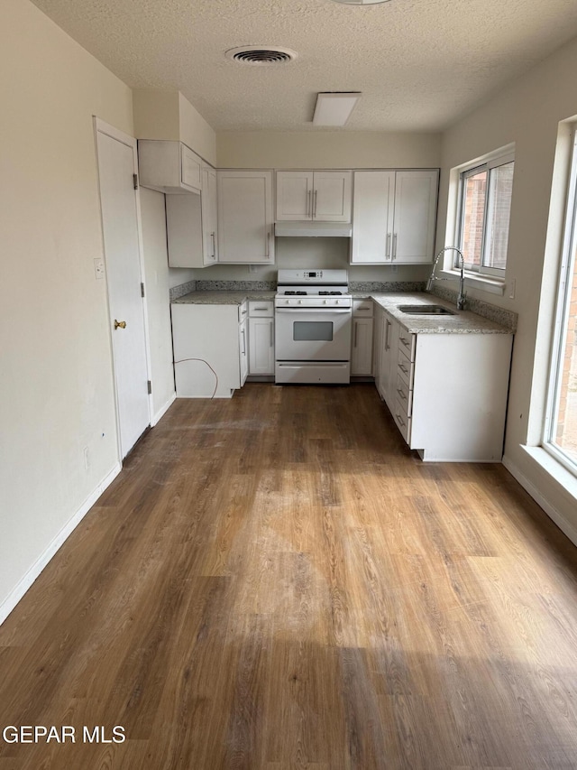 kitchen featuring visible vents, dark wood-style flooring, a sink, a textured ceiling, and white gas range