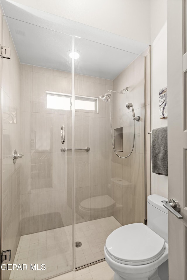 full bathroom featuring a shower stall and toilet