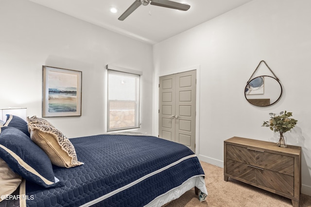 bedroom with light carpet, ceiling fan, and baseboards